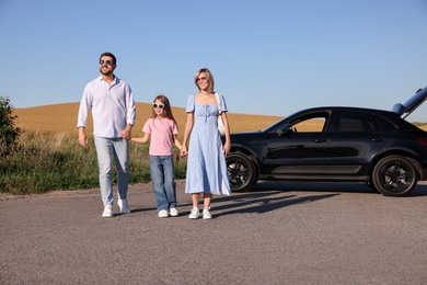 Parents, their daughter and car outdoors. Family traveling