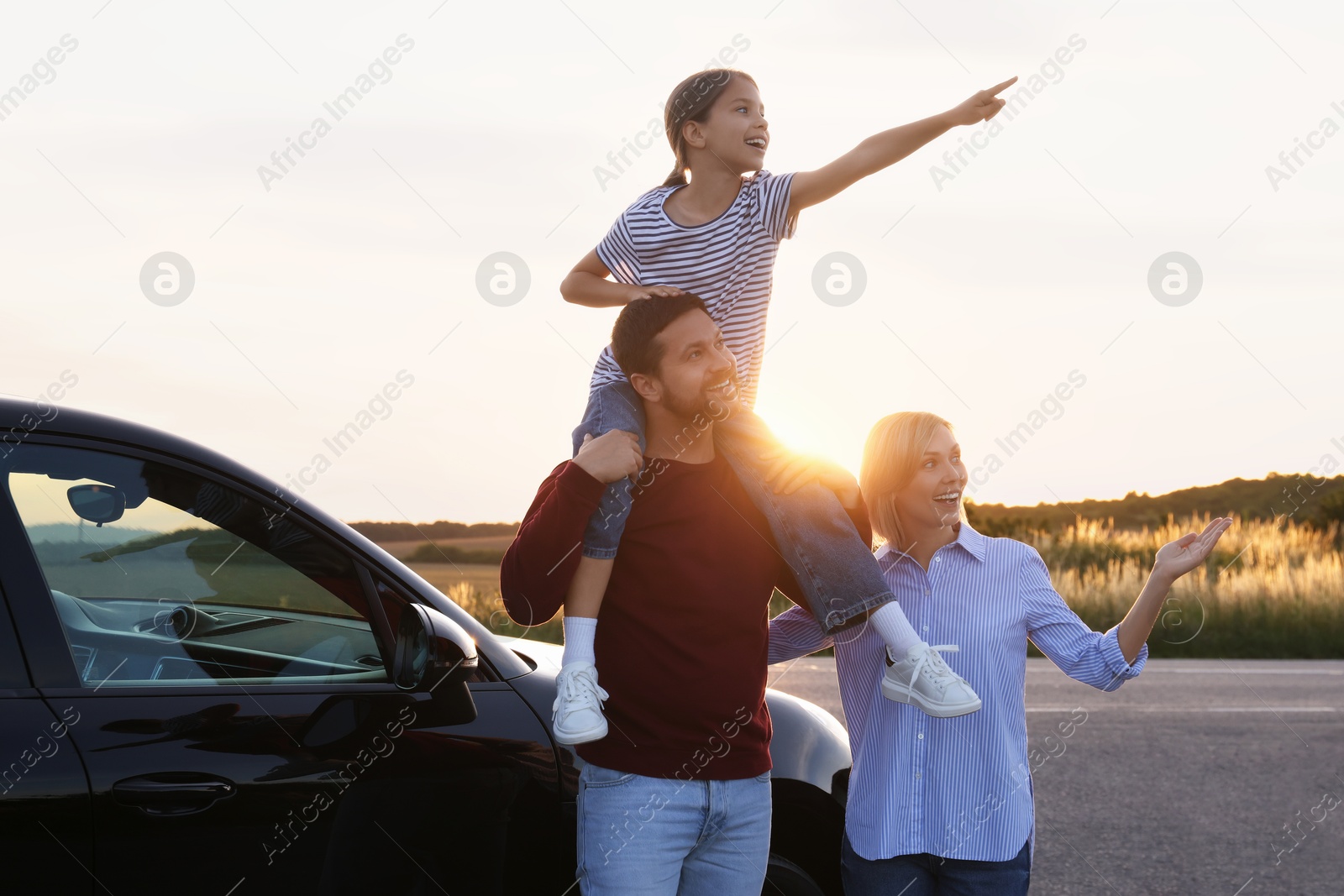 Photo of Happy parents and their daughter near car outdoors