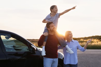 Happy parents and their daughter near car outdoors