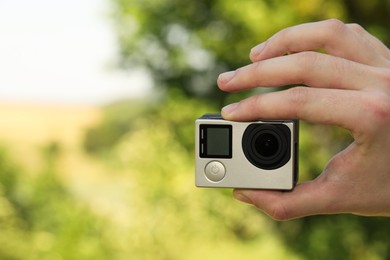 Photo of Man with modern action camera outdoors, closeup. Space for text