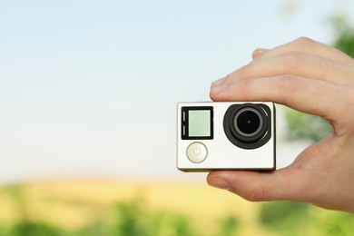 Photo of Man with modern action camera outdoors, closeup. Space for text