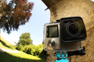 Modern action camera with monopod outdoors. Fisheye lens effect