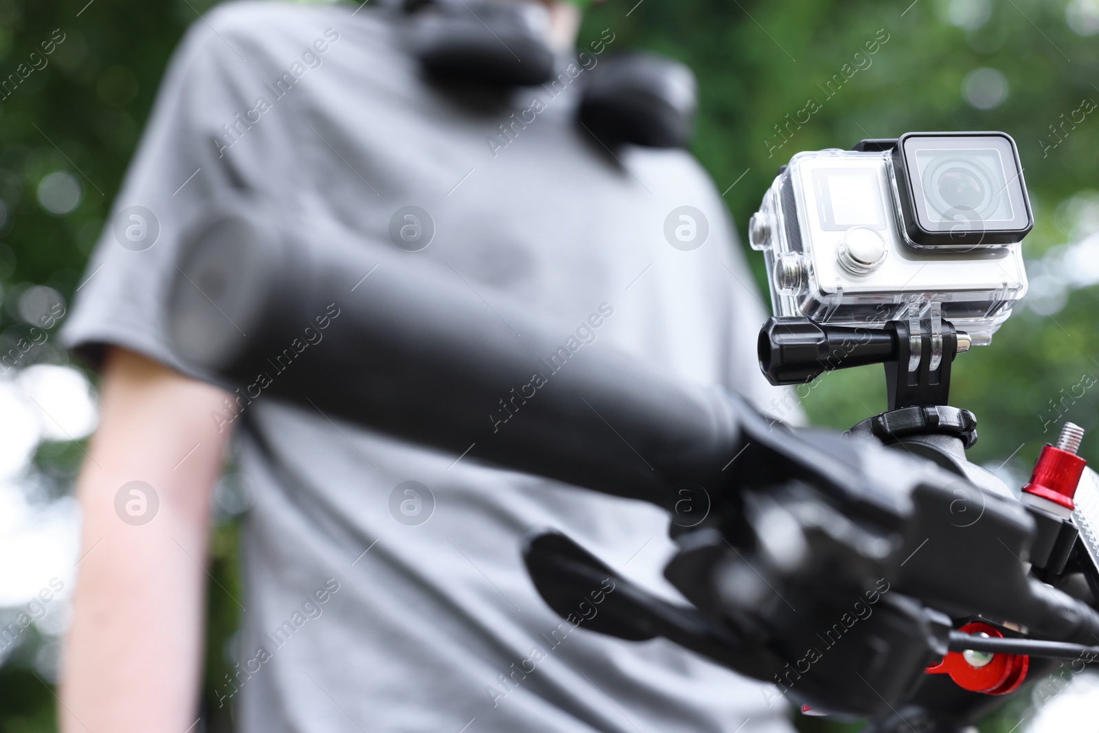 Photo of Man near bicycle with modern action camera outdoors, closeup