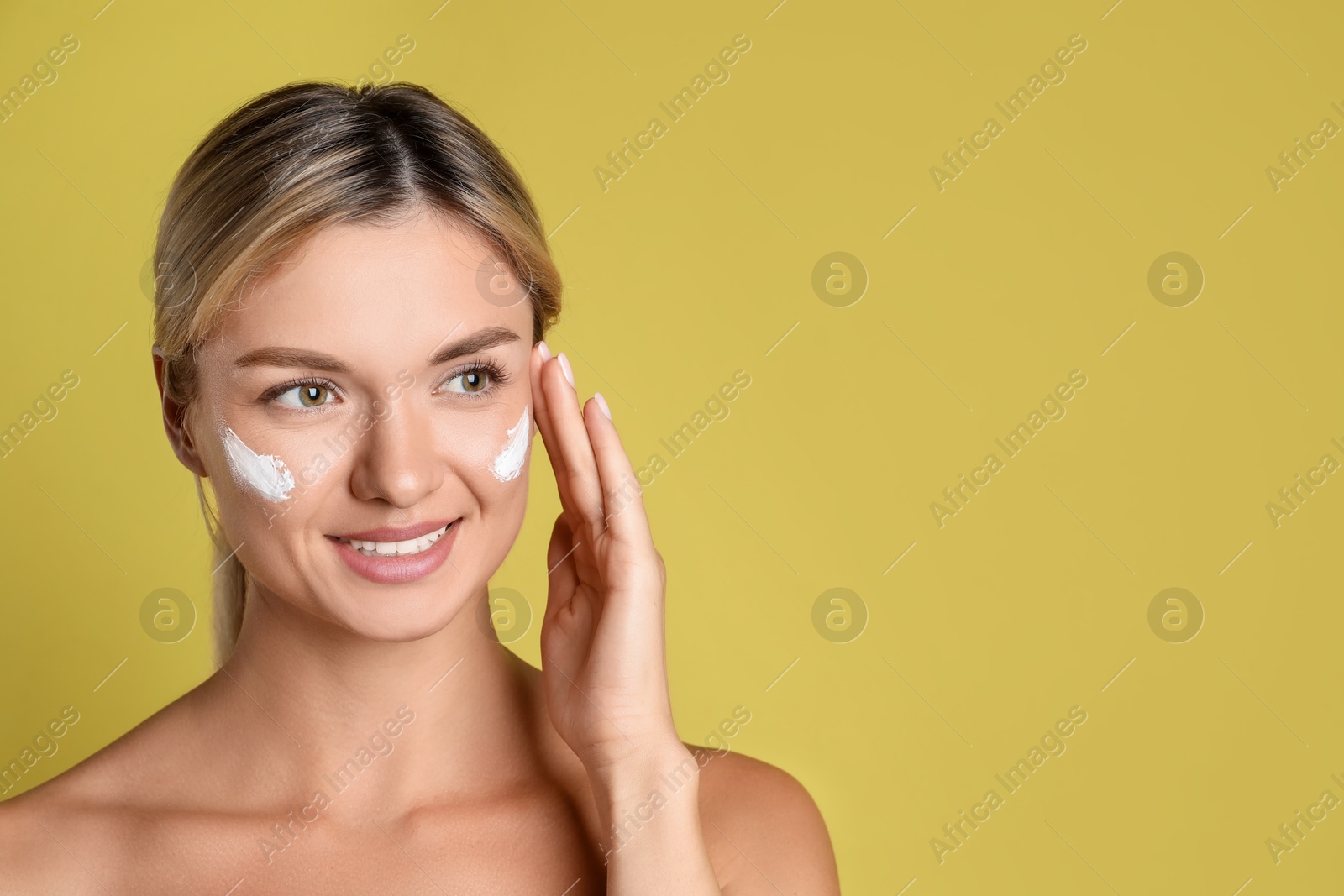 Photo of Beautiful woman with cream on her face against olive background, space for text