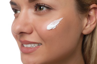 Beautiful woman with cream on her face against white background, closeup