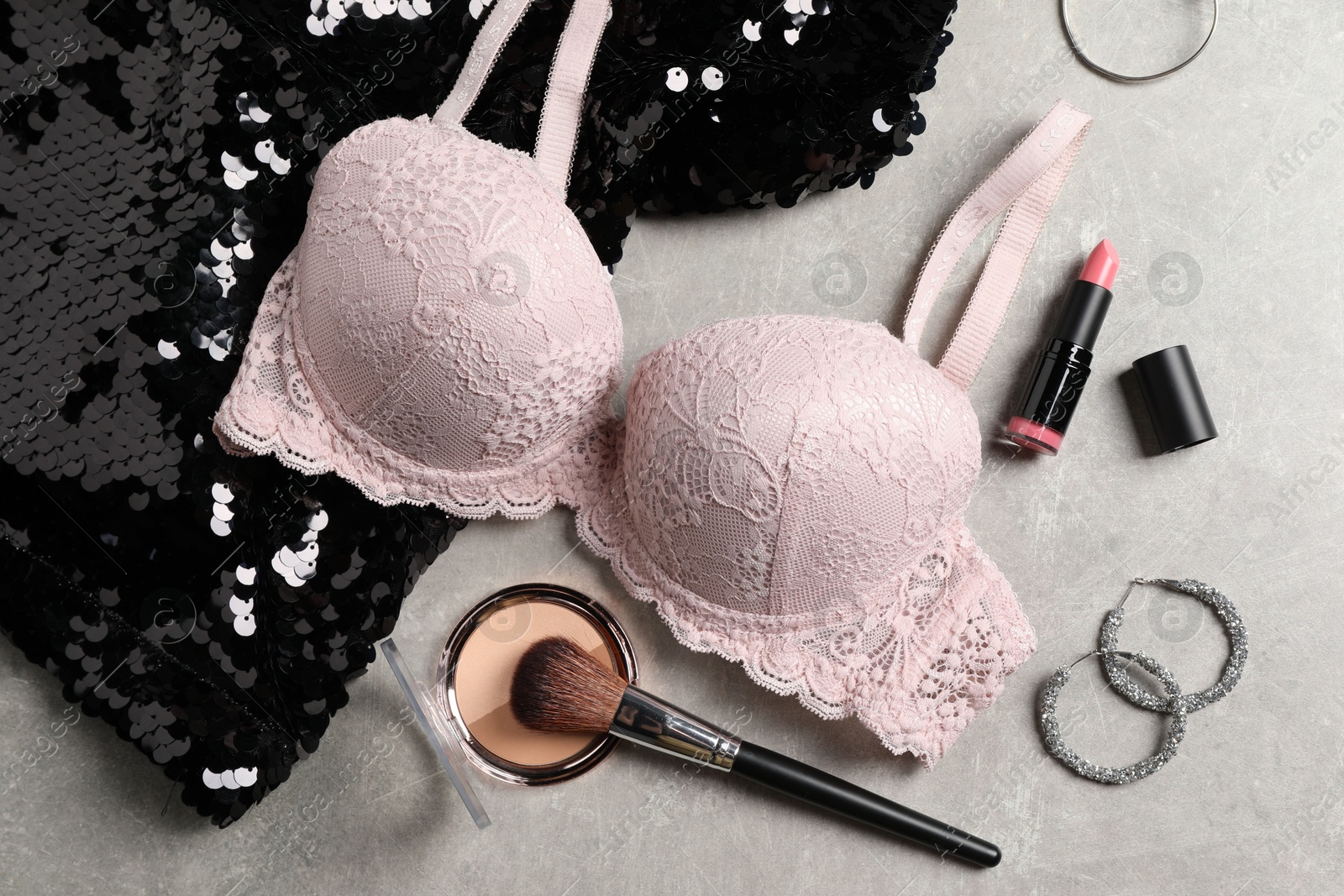 Photo of Beautiful lace bra and accessories on grey background, flat lay