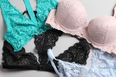 Photo of Different lace bras on grey background, top view