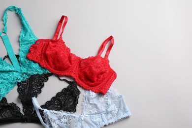 Photo of Different lace bras on grey background, top view. Space for text