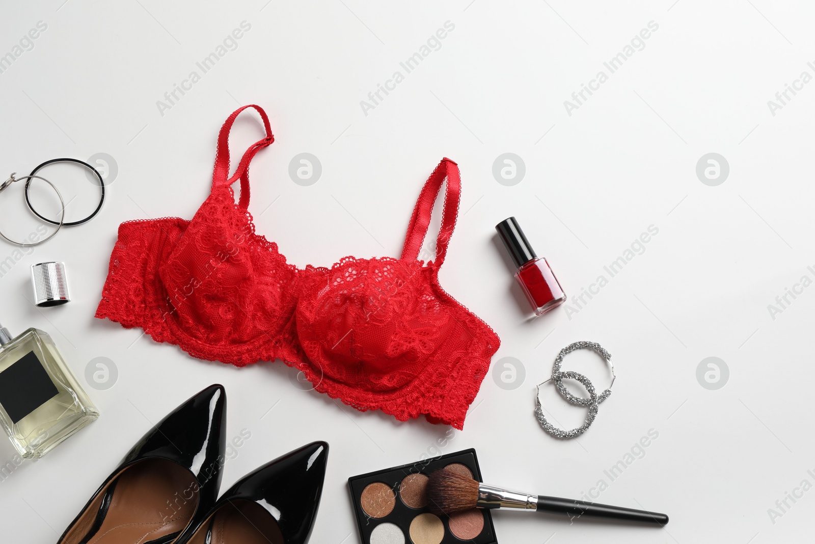 Photo of Beautiful lace bra and accessories on white background, flat lay