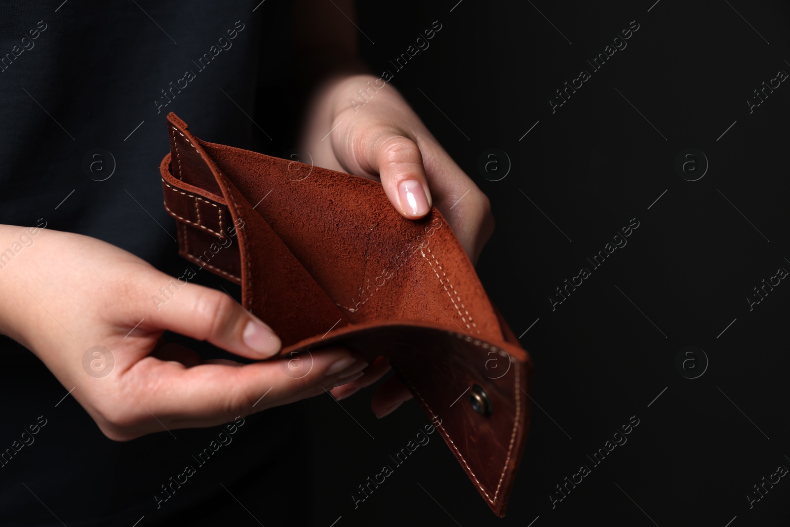 Photo of Woman with empty wallet on dark background, closeup