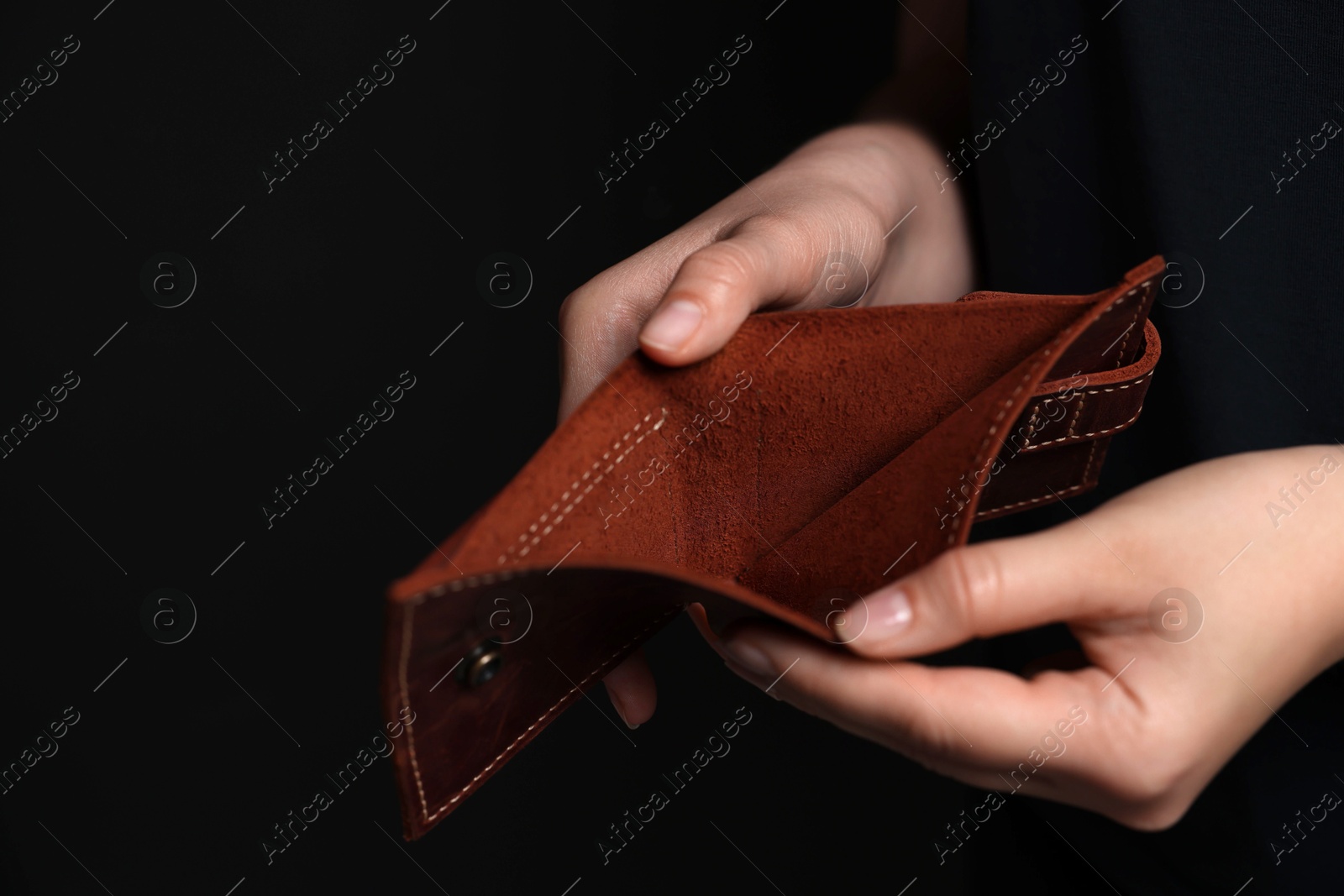 Photo of Woman with empty wallet on dark background, closeup