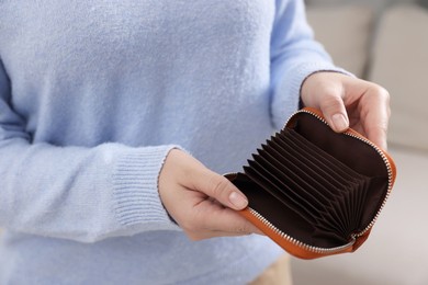 Photo of Woman with empty wallet indoors, closeup view