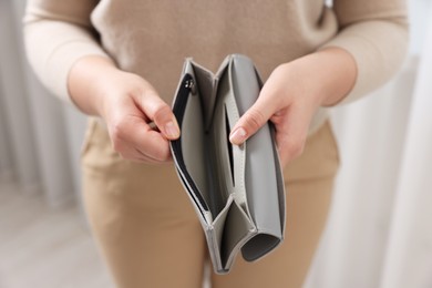 Photo of Woman with empty wallet indoors, closeup view