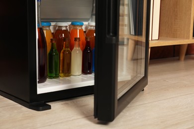 Modern mini refrigerator with drinks indoors, closeup