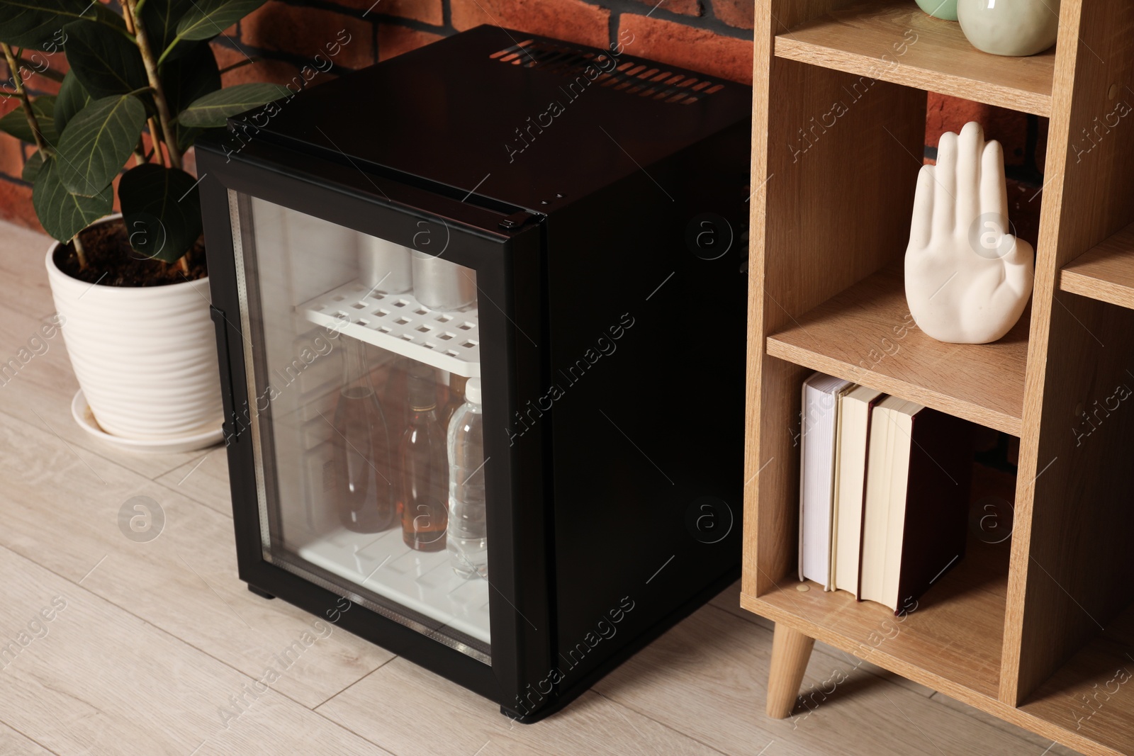 Photo of Modern mini refrigerator with drinks at home