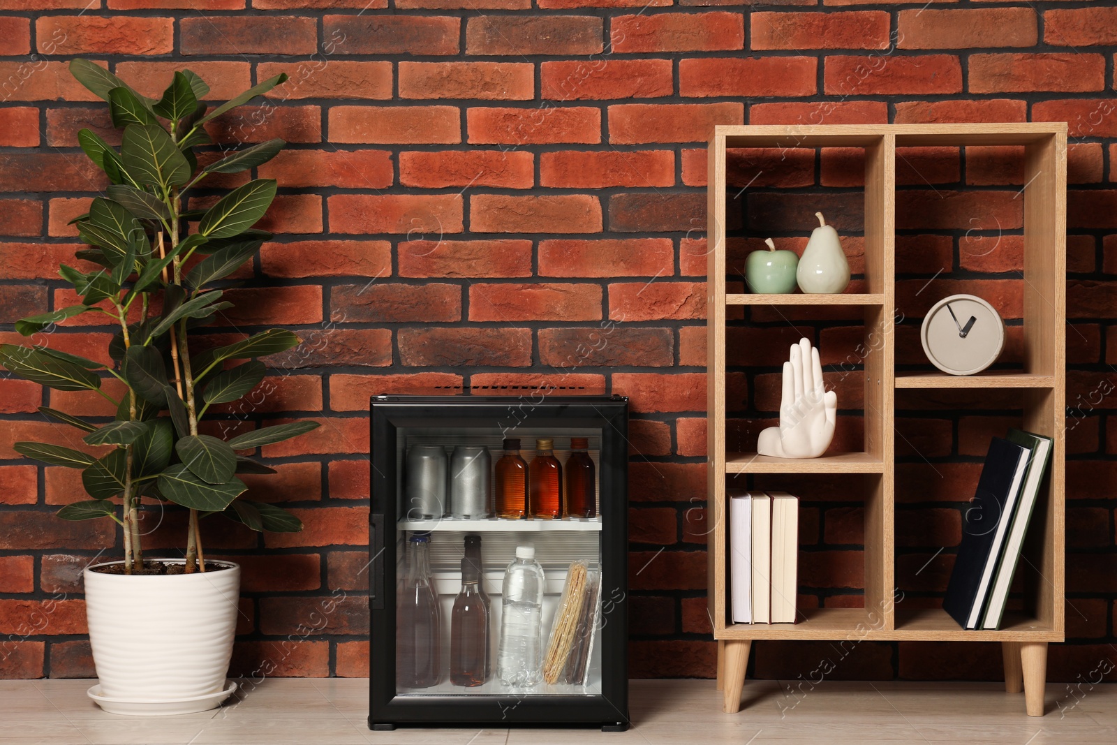 Photo of Mini refrigerator with drinks and snacks indoors