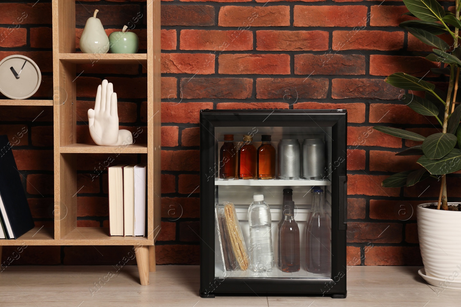 Photo of Mini refrigerator with drinks and snacks indoors