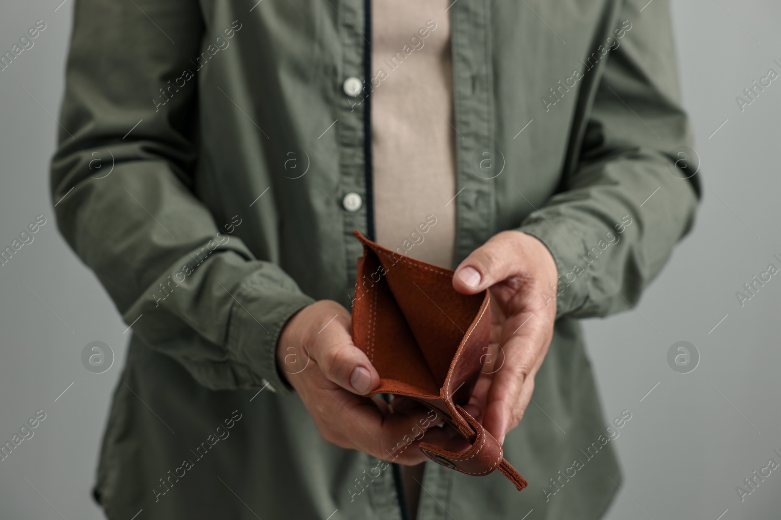 Photo of Man with empty wallet on grey background, closeup