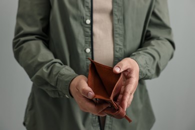 Photo of Man with empty wallet on grey background, closeup