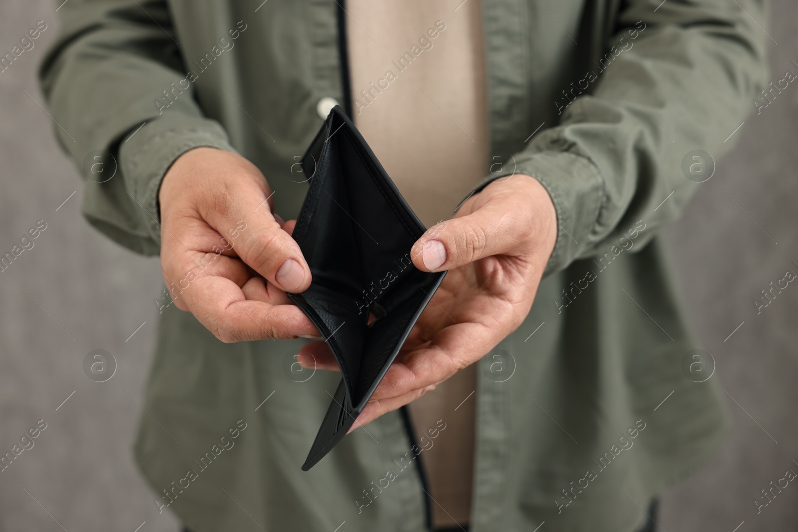 Photo of Man with empty wallet on blurred background, closeup