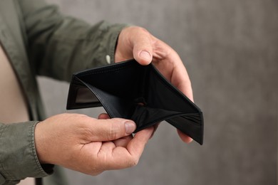 Photo of Man with empty wallet on blurred background, closeup