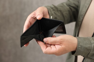 Photo of Man with empty wallet on blurred background, closeup