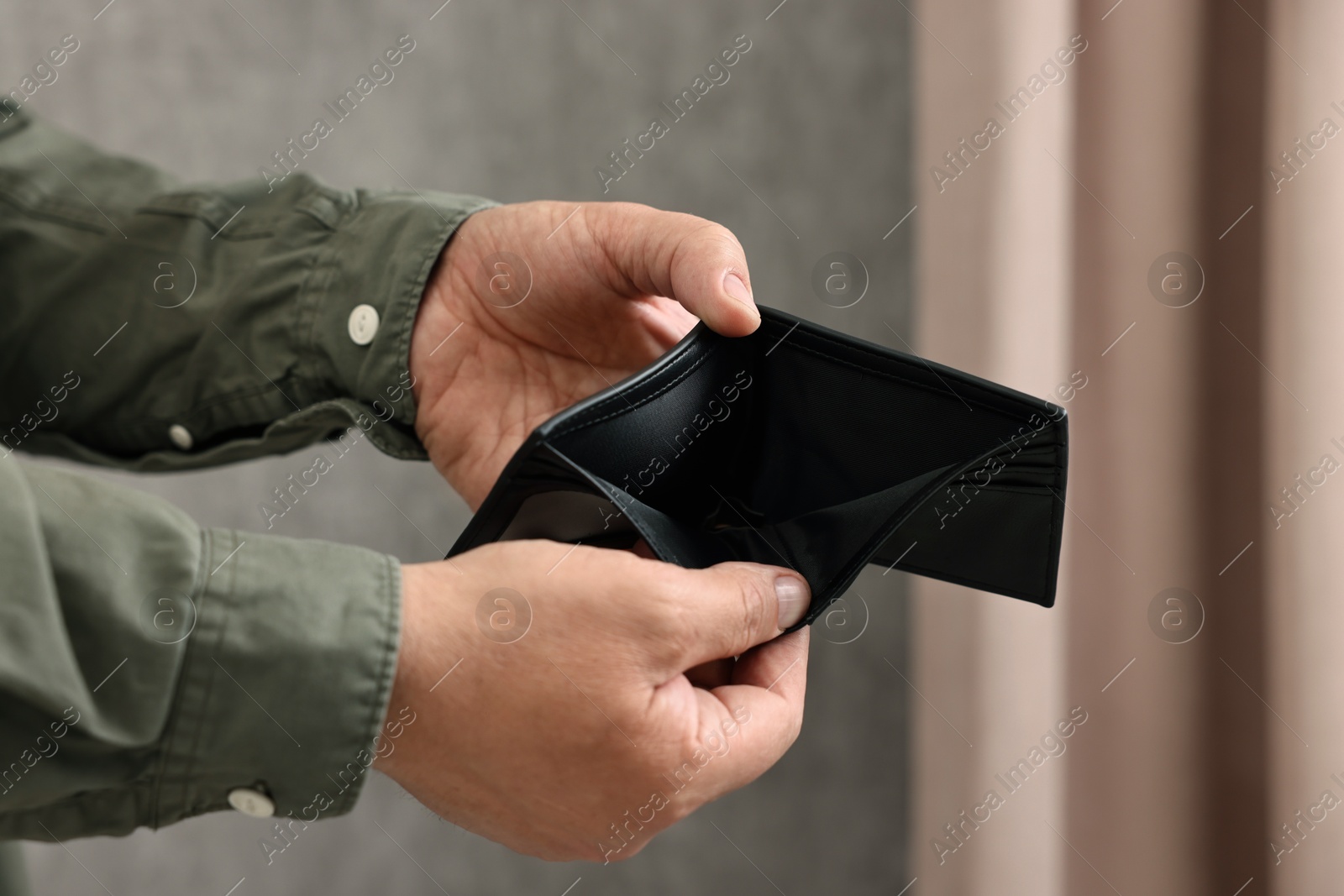 Photo of Man with empty wallet at home, closeup