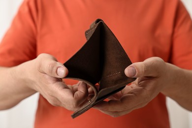 Photo of Man with empty wallet on blurred background, closeup