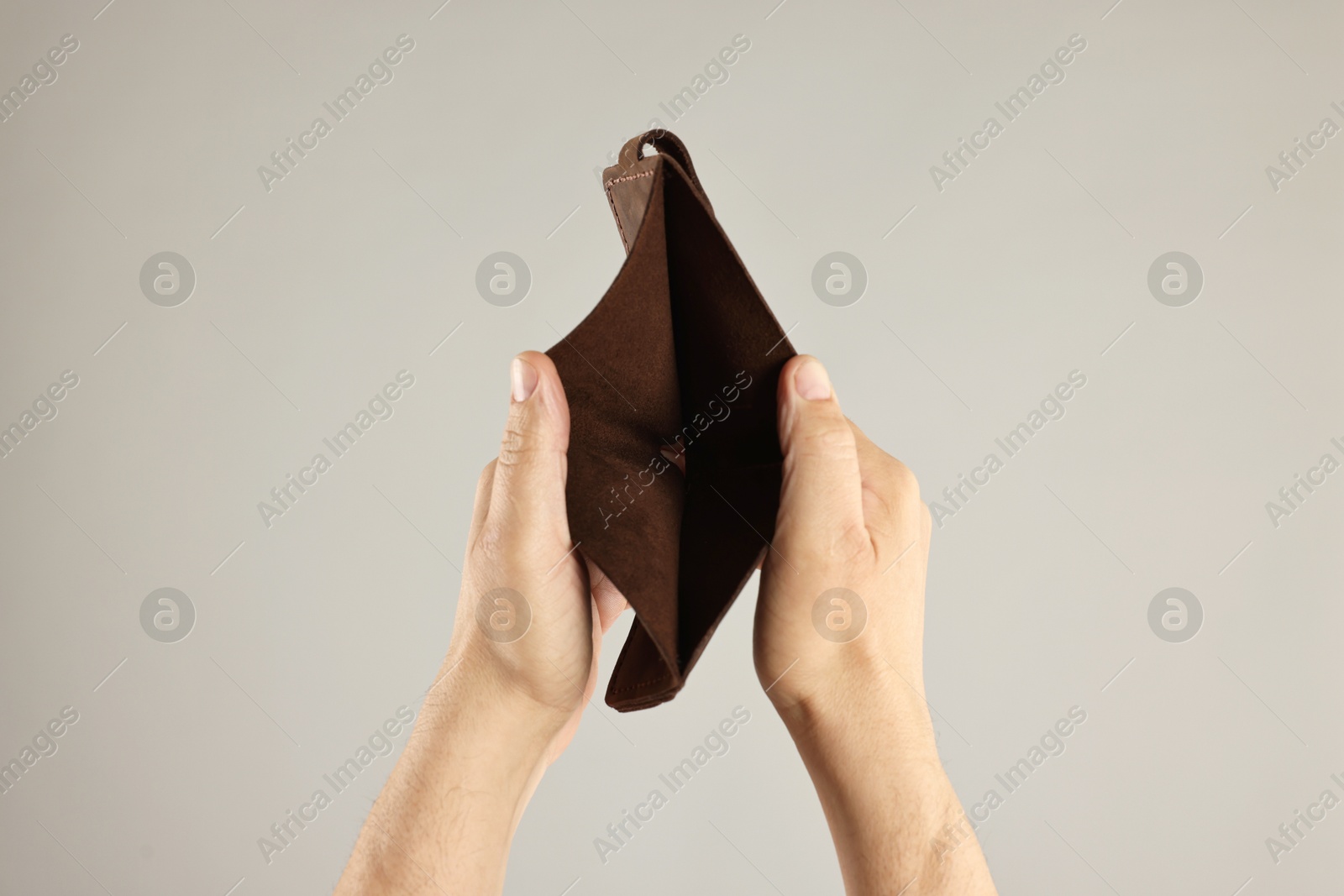 Photo of Man with empty wallet on grey background, closeup