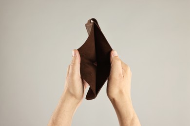 Photo of Man with empty wallet on grey background, closeup