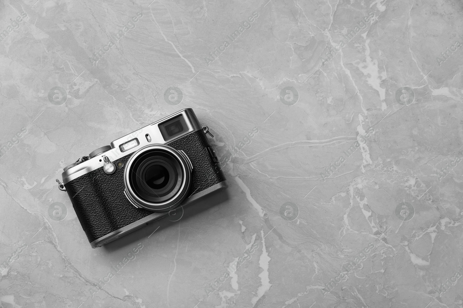 Photo of Vintage photo camera on grey marble table, top view. Space for text