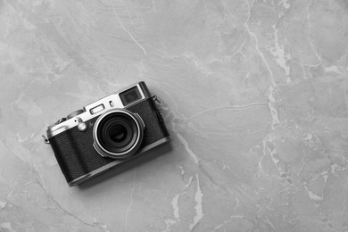 Vintage photo camera on grey marble table, top view. Space for text