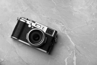 Vintage photo camera on grey marble table, top view. Space for text