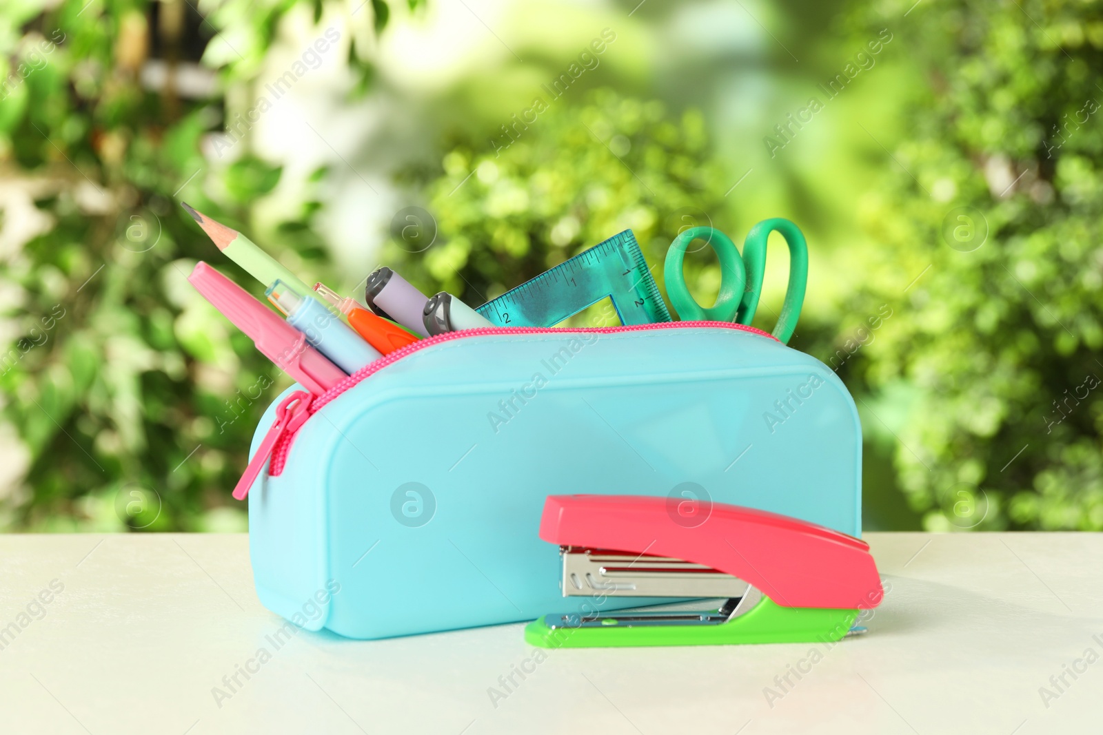 Photo of Stapler, pencil case and other different stationery on white table