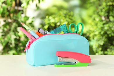 Stapler, pencil case and other different stationery on white table