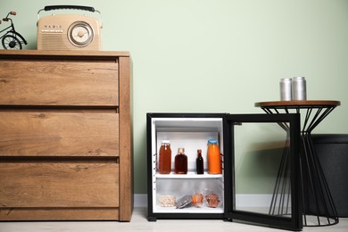 Mini refrigerator with different drinks and snacks indoors