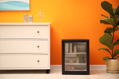 Mini refrigerator with different drinks and snacks indoors