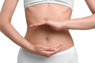 Photo of Healthy digestion. Woman holding something near her belly on white background, closeup