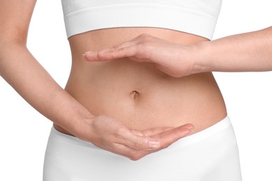 Photo of Healthy digestion. Woman holding something near her belly on white background, closeup