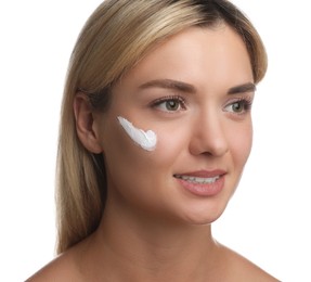 Beautiful woman with cream on her face against white background