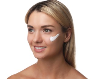 Beautiful woman with cream on her face against white background