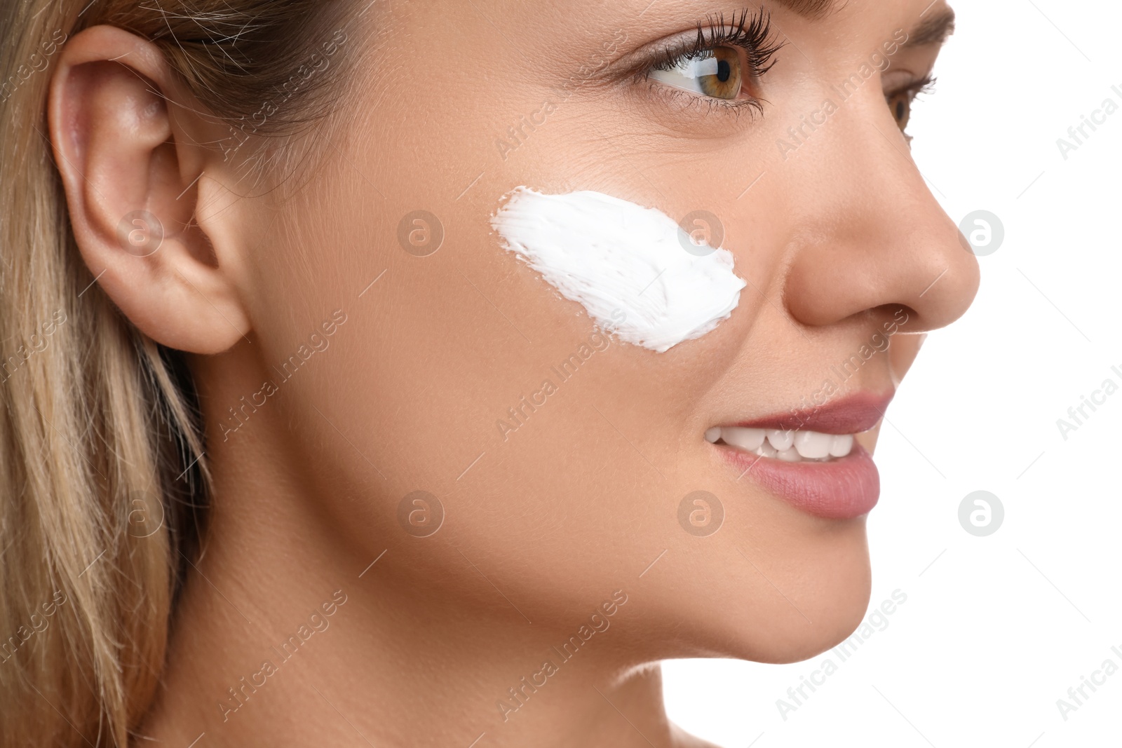 Photo of Beautiful woman with cream on her face against white background, closeup