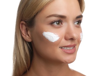 Beautiful woman with cream on her face against white background, closeup