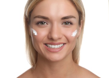 Beautiful woman with cream on her face against white background