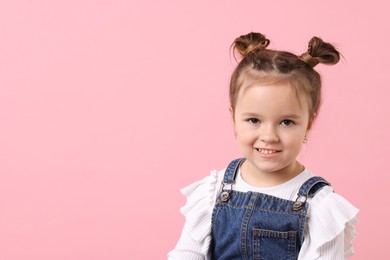 Photo of Portrait of happy little girl on pink background, space for text