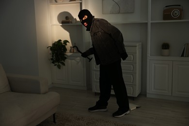 Photo of Thief with crowbar sneaking at foreign house. Burglary