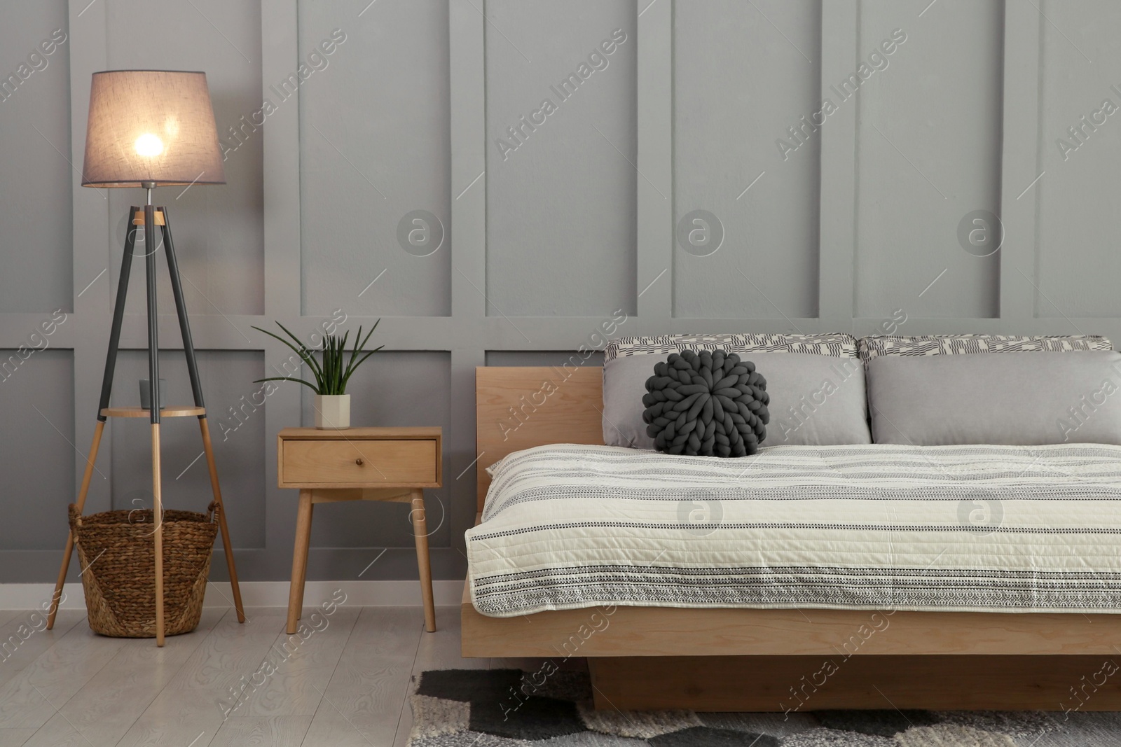 Photo of Stylish bedroom interior with comfortable bed and floor lamp