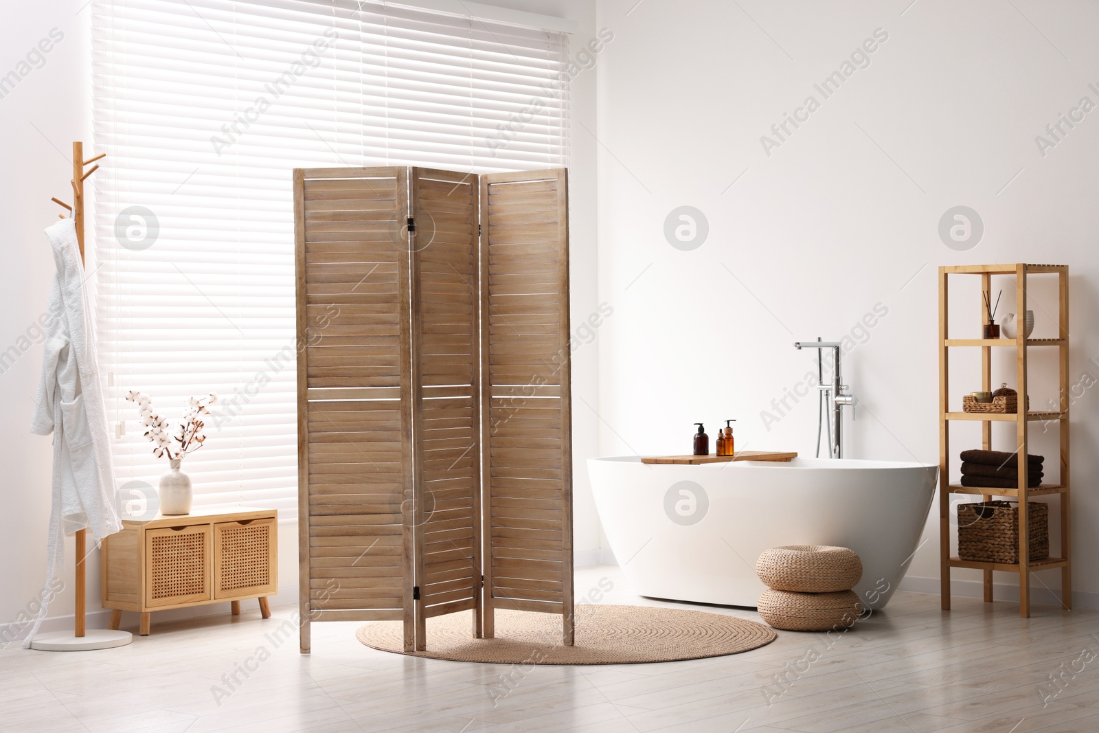 Photo of Wooden folding screen, bathtub, rack and cabinet in bathroom