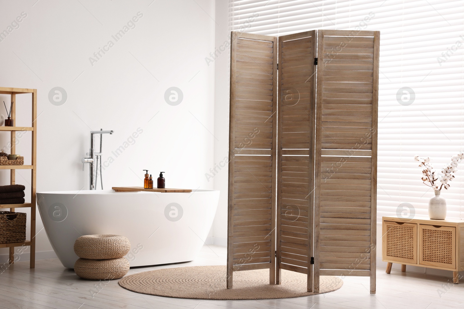 Photo of Wooden folding screen, bathtub, rack and cabinet in bathroom