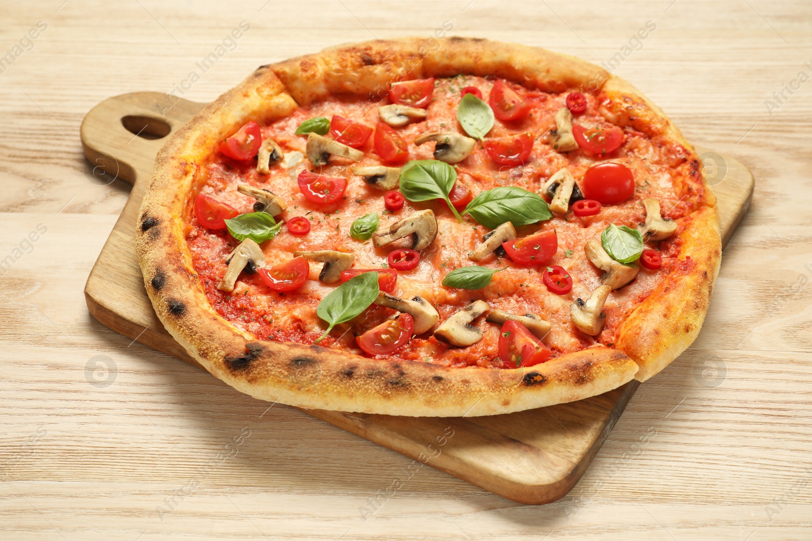 Photo of Delicious pizza with tomatoes, mushrooms and basil on wooden table, closeup